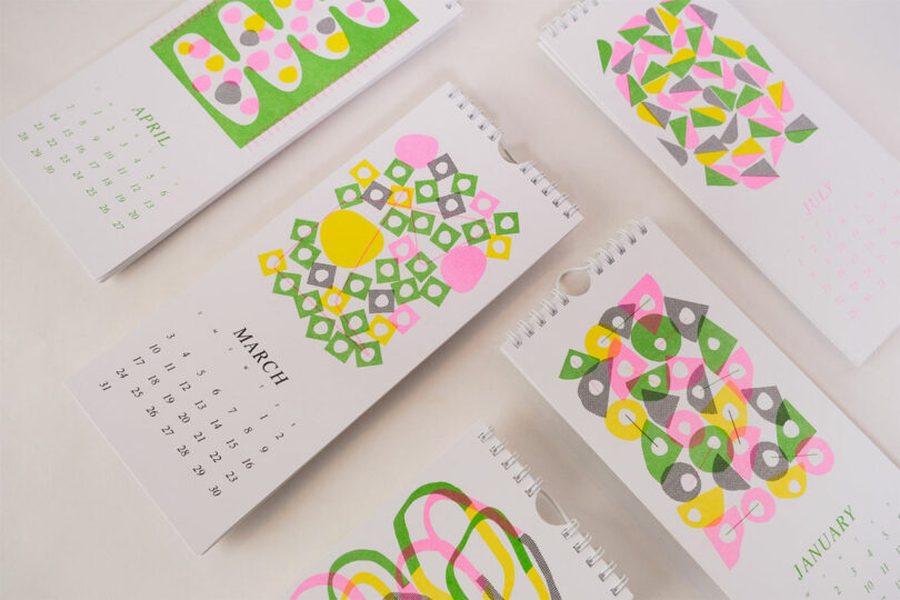 down view of angled vertical calendar pages with neon risograph geometric patterns