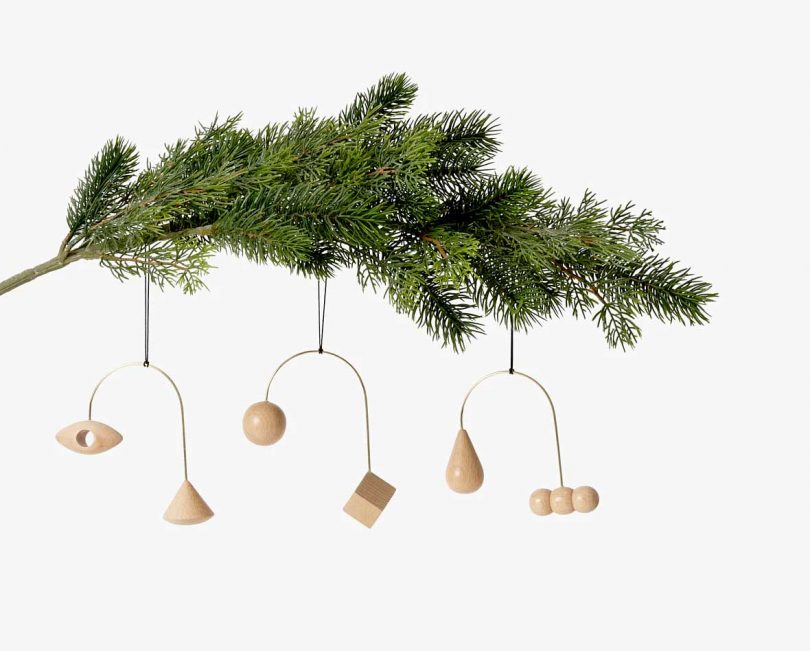 areaware brass and wood ornaments hanging from tree branch