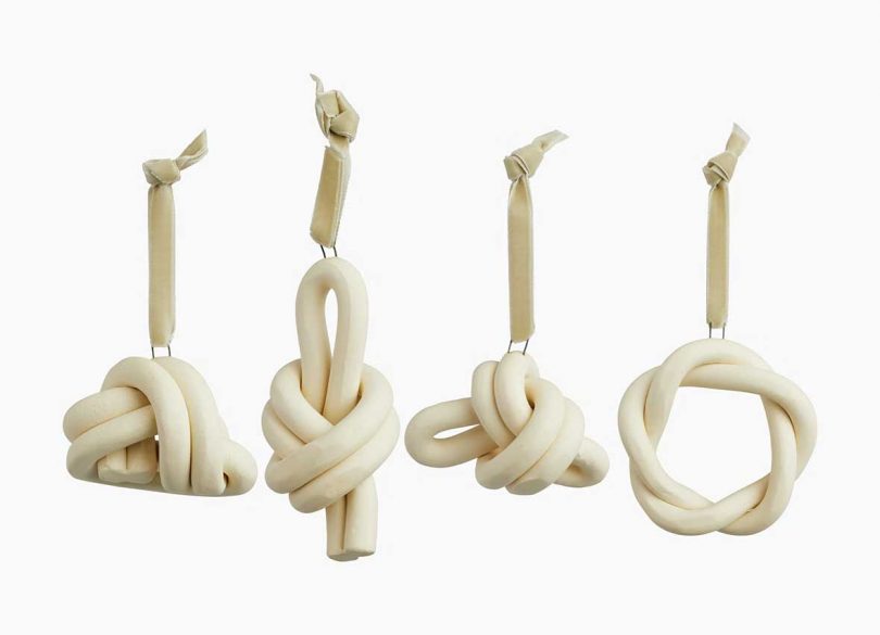 four white knotted ceramic christmas ornaments hanging