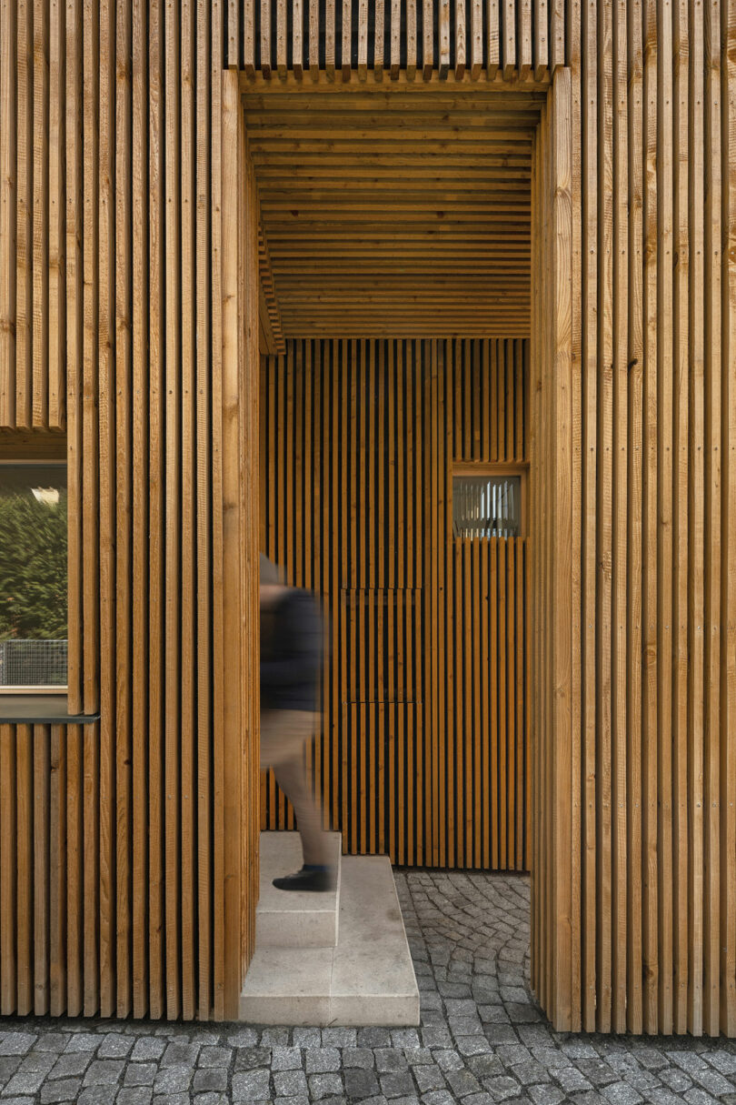 view into covered entryway into modern house clad in wood slats