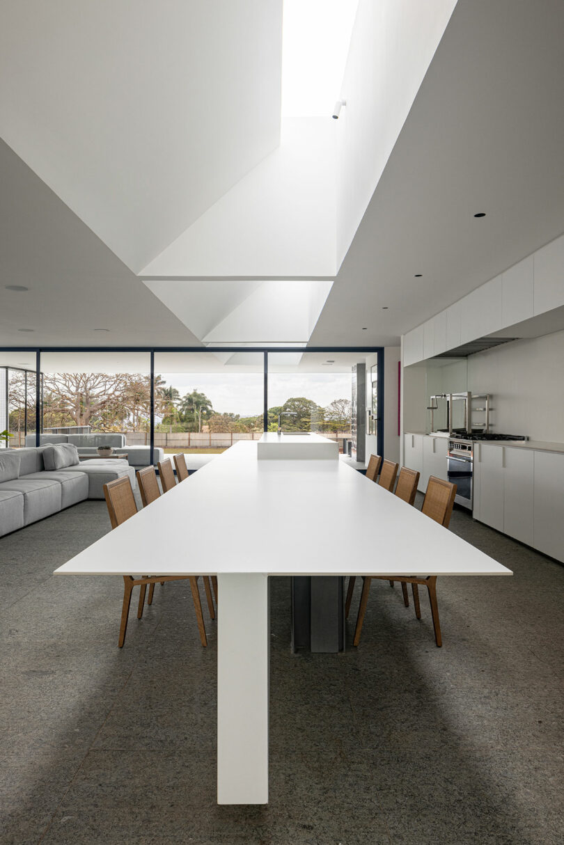 view of modern interior down long white kitchen island that doubles as a table