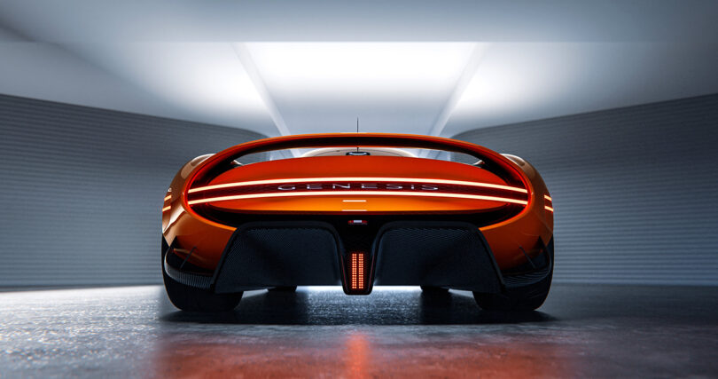 Rear detail view of magma orange paint colored Genesis X Gran Berlinetta Vision Gran Turismo Concept and its elliptical spoiler