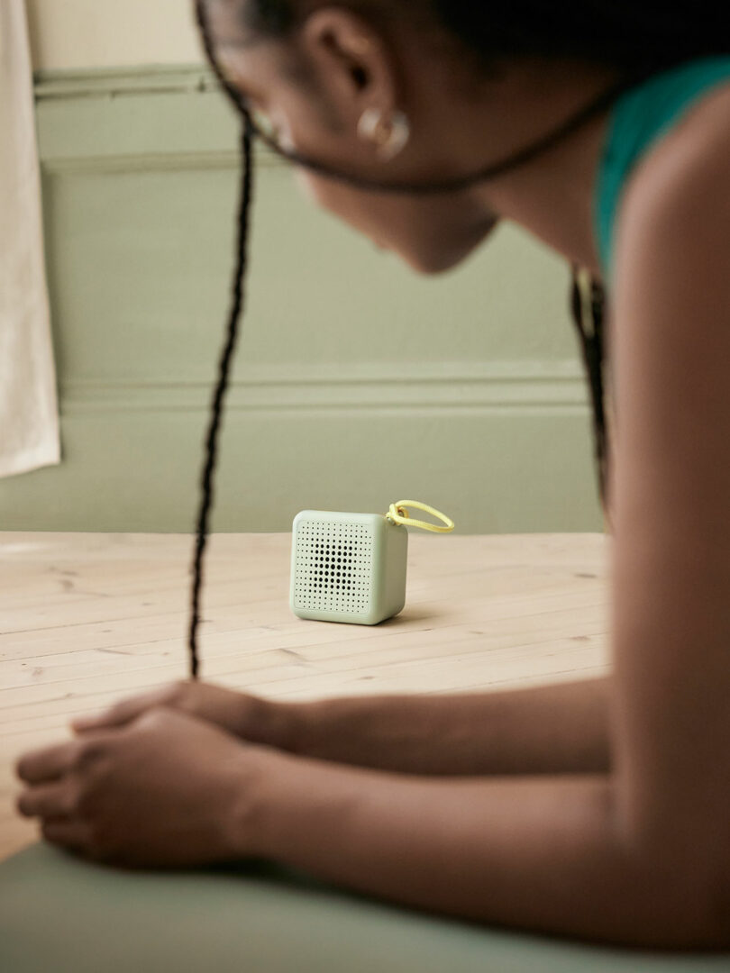 closeup side view of woman on bent arms looking at small green radio