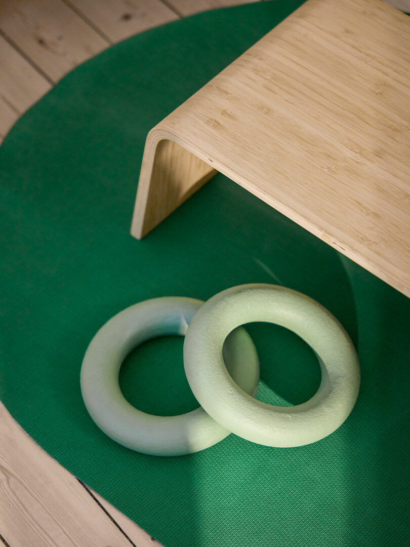 angled down shot of two light green weight rings on top of darker green fitness mat