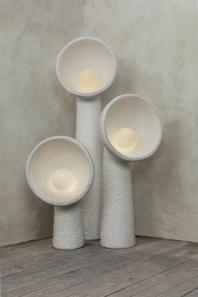 three white sculptural floor lamps