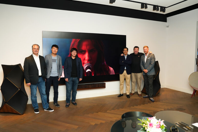 A group photo taken in front of the Bang and Olufsen and LG MAGNIT home theater bundle inside Bang & Olufsen’s Costa Mesa, California showroom in September 2023.