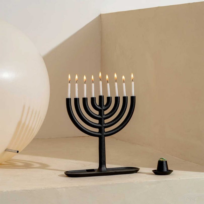 black cast iron menorah candelabra with lit candles