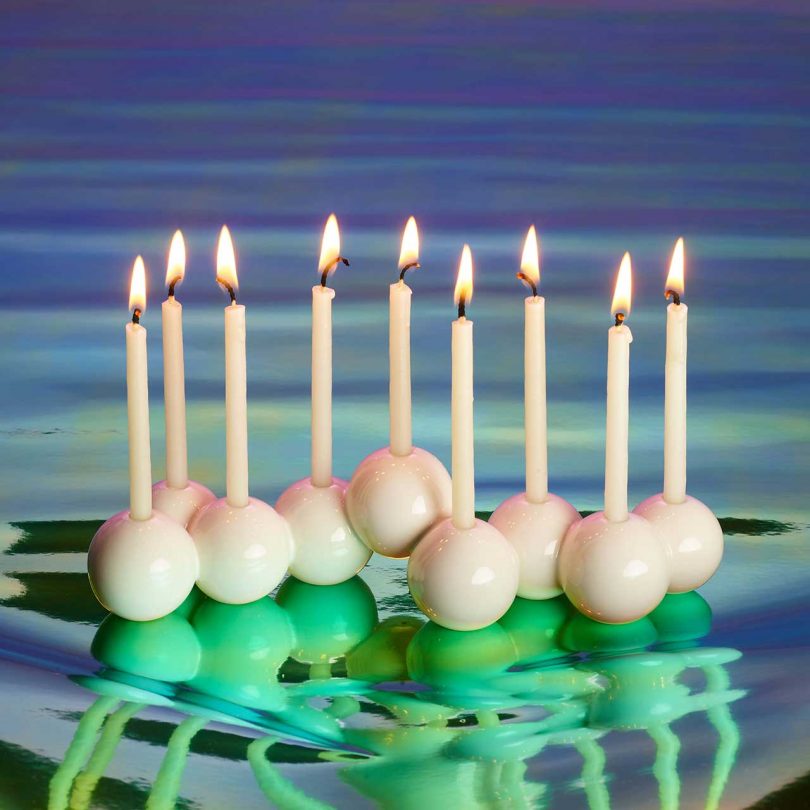 modern white bubble menorah with gradient background and candles lit