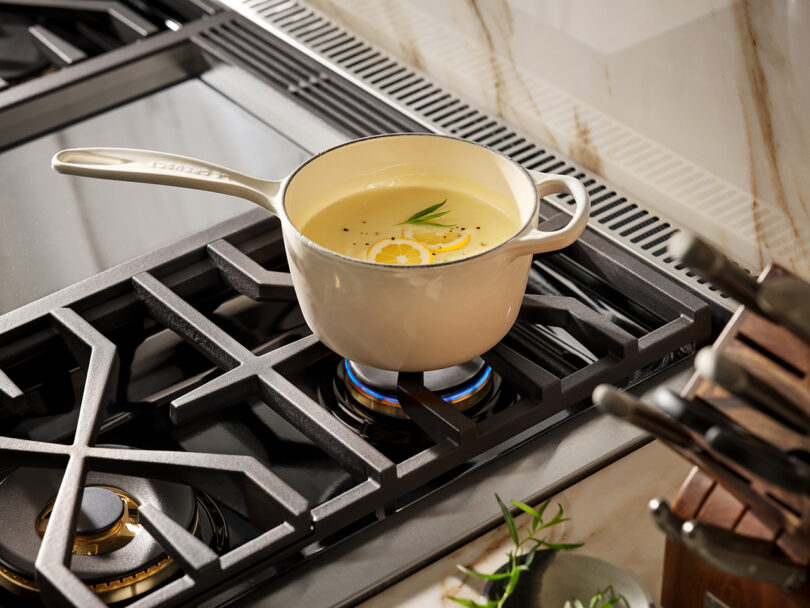 stainless steel range top with sauce pot simmering on a burner