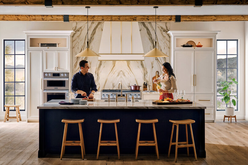 styled kitchen with two light-skinned people at the island