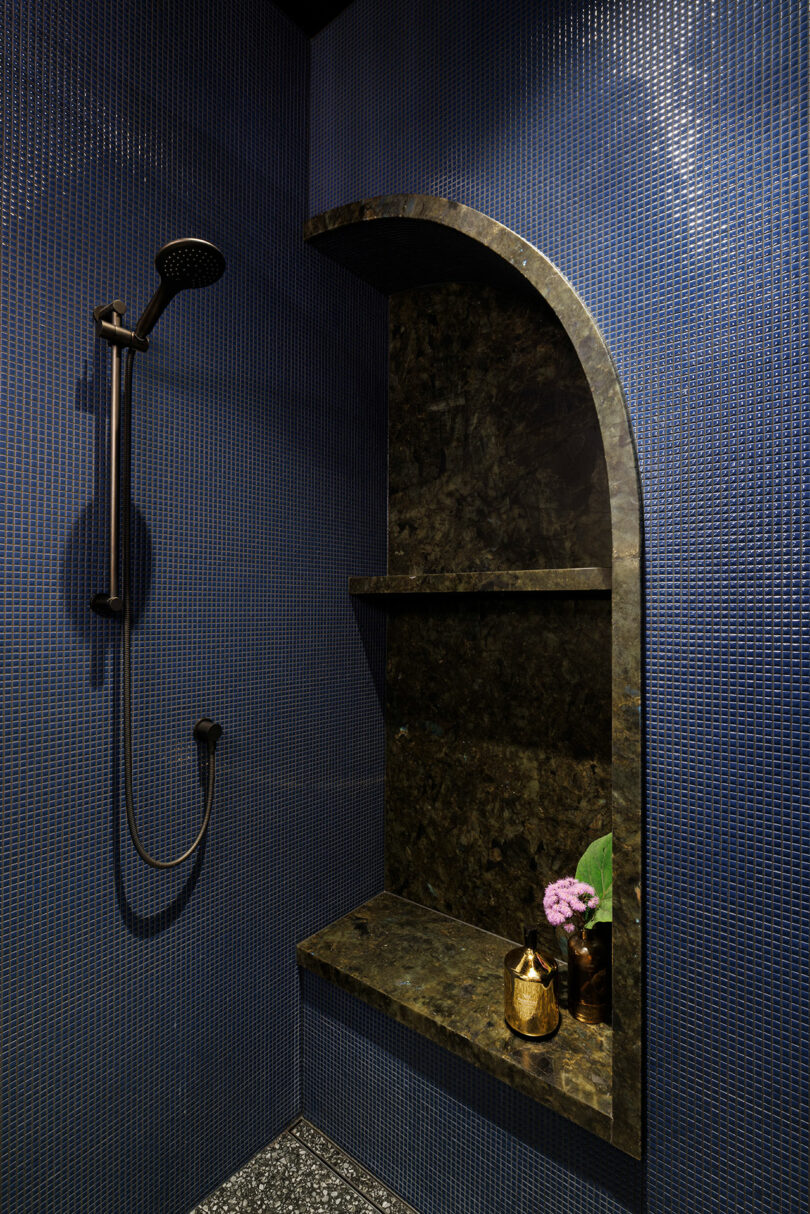 angled view of dark blue tiled bathroom
