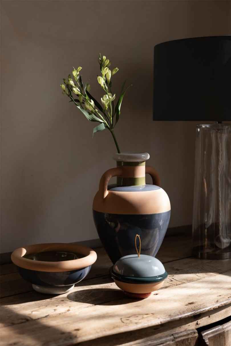 blue and light brown ceramic vase, bowl, and cup on a wood surface